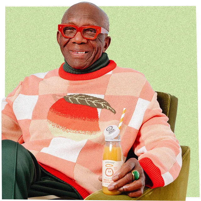 man in a big knitwear jumper drinking an innocent smoothie